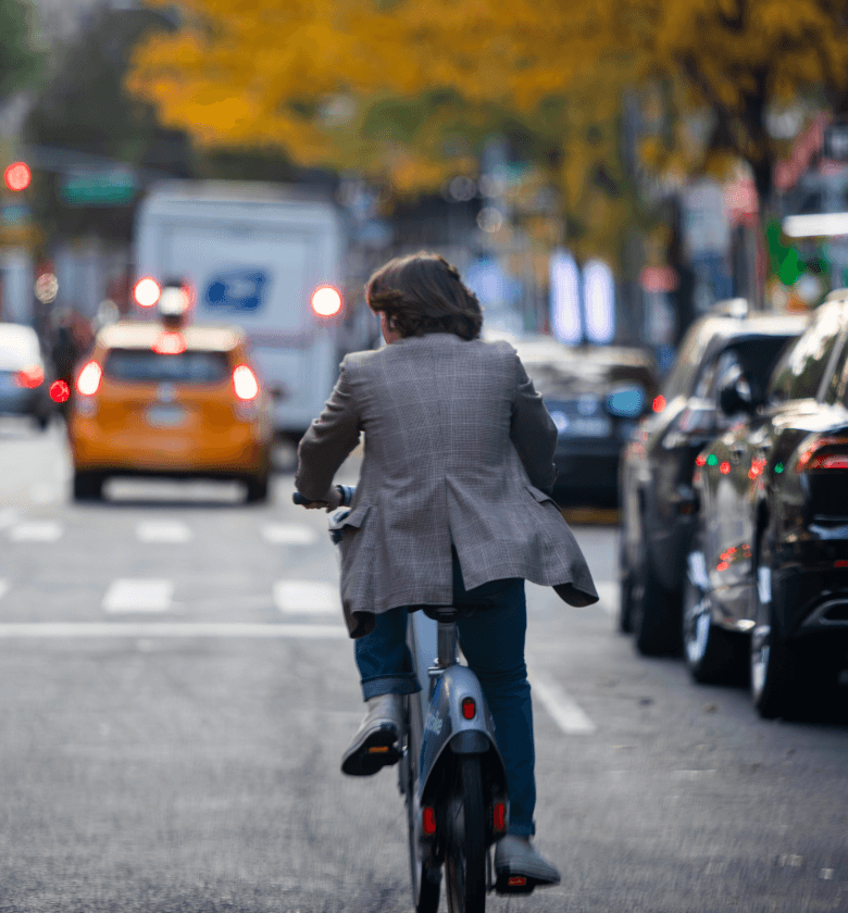 A man riding a bike near The Henry Residences on the Upper West Side by Naftali Group, showcasing urban life and activity.