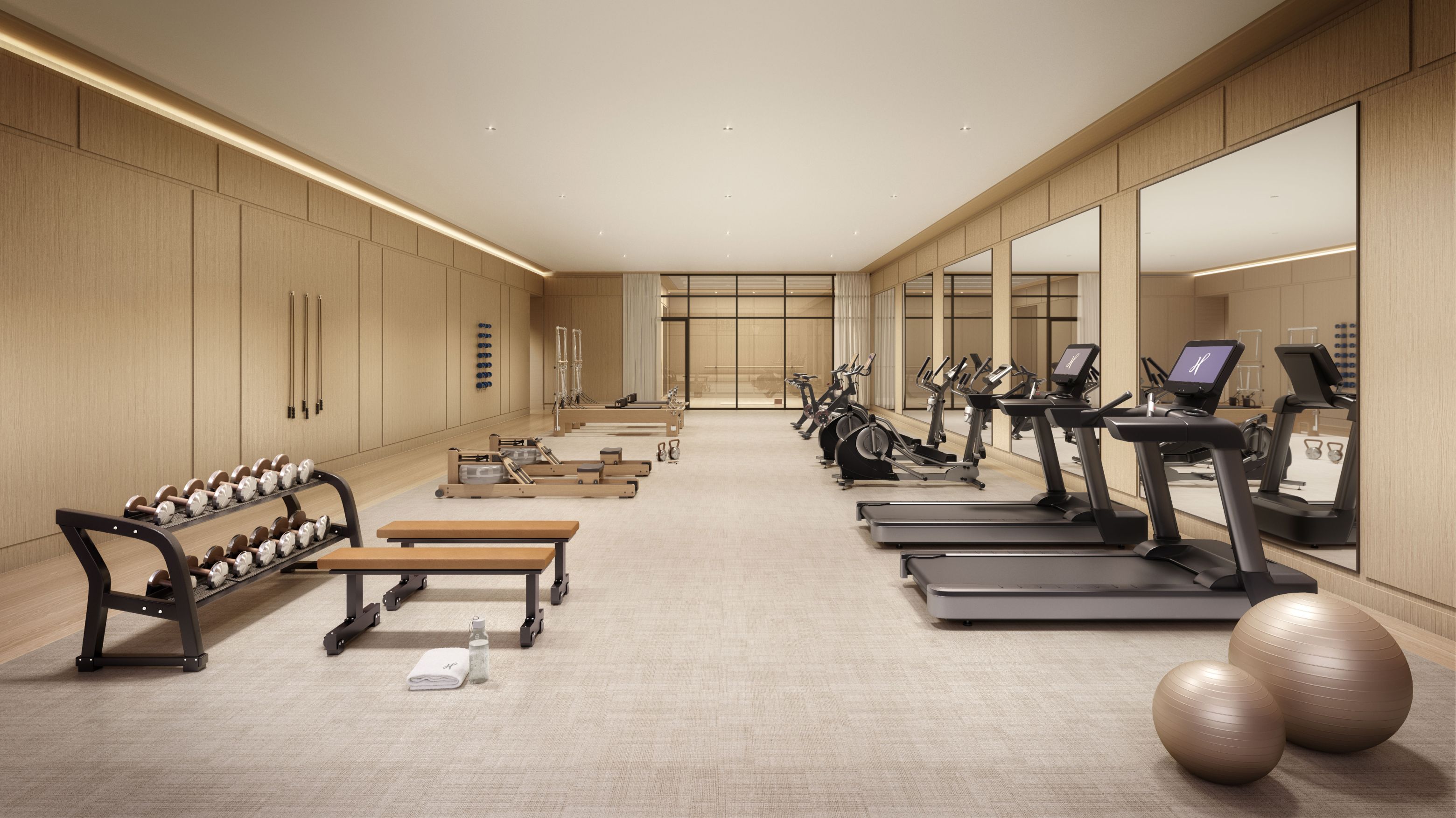 Luxury fitness center at The Henry Condominiums with exercise equipment and mirrors, enhancing wellness in UWS living.